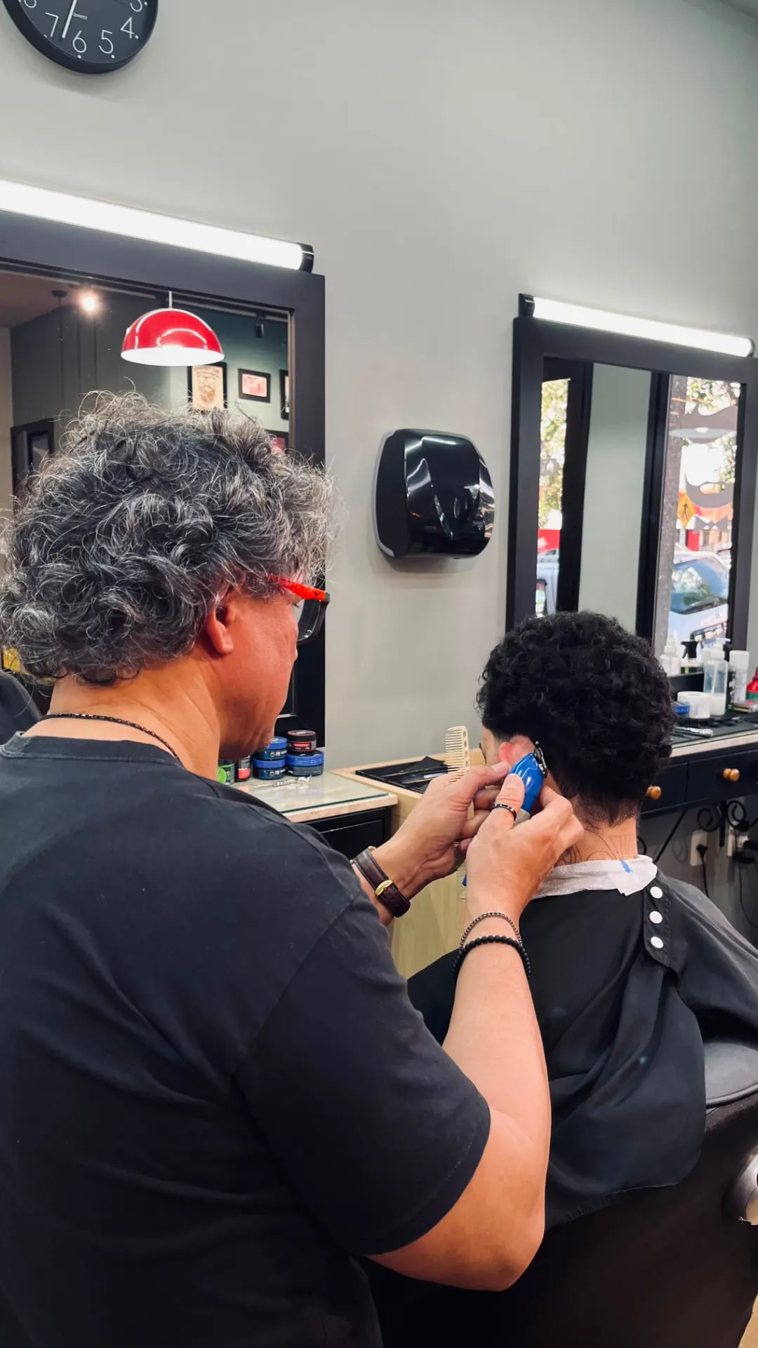 Barbeiro realizando acabamento em cliente na barbearia